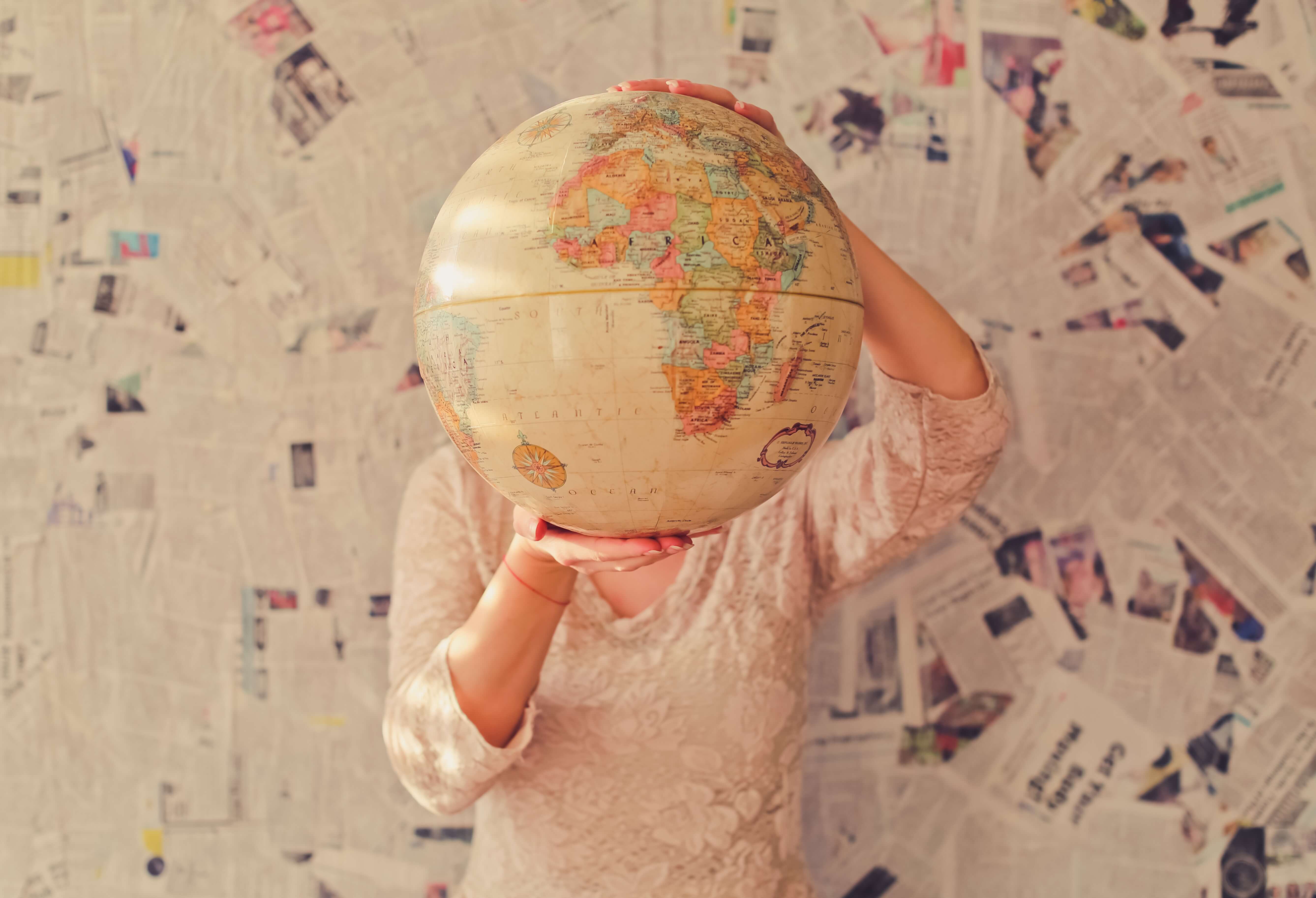 Photo: person holding a globe over their face