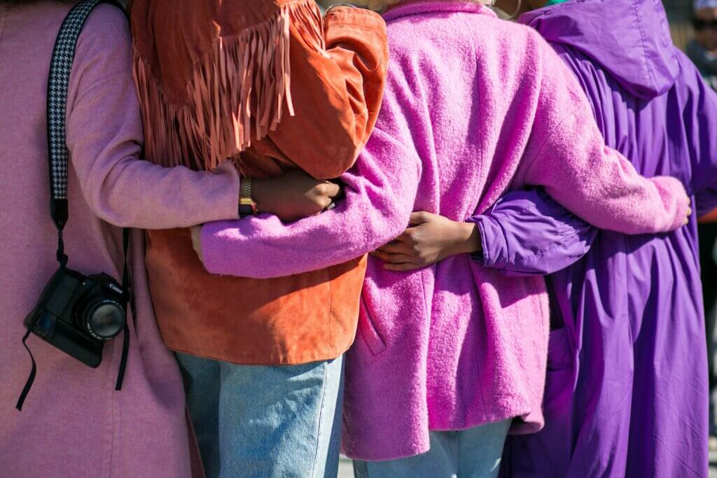 view of women linking arms together.