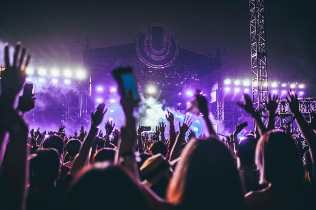 Group of people raising their hands at a concert