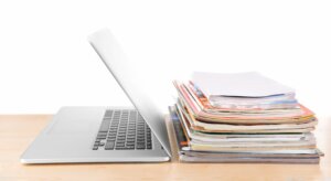 Laptop and pile of papers